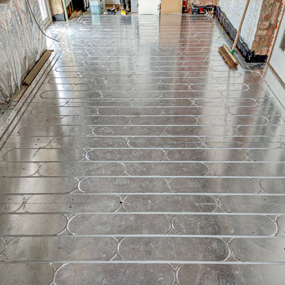 Newly installed foil back grooved chipboard for underfloor heating pipe systems