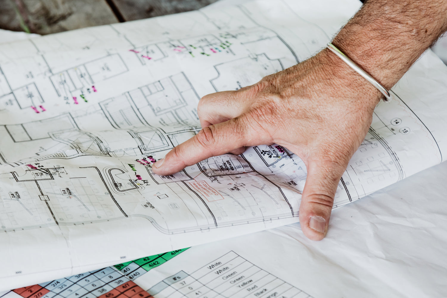 Hand pointing at a floor building plan